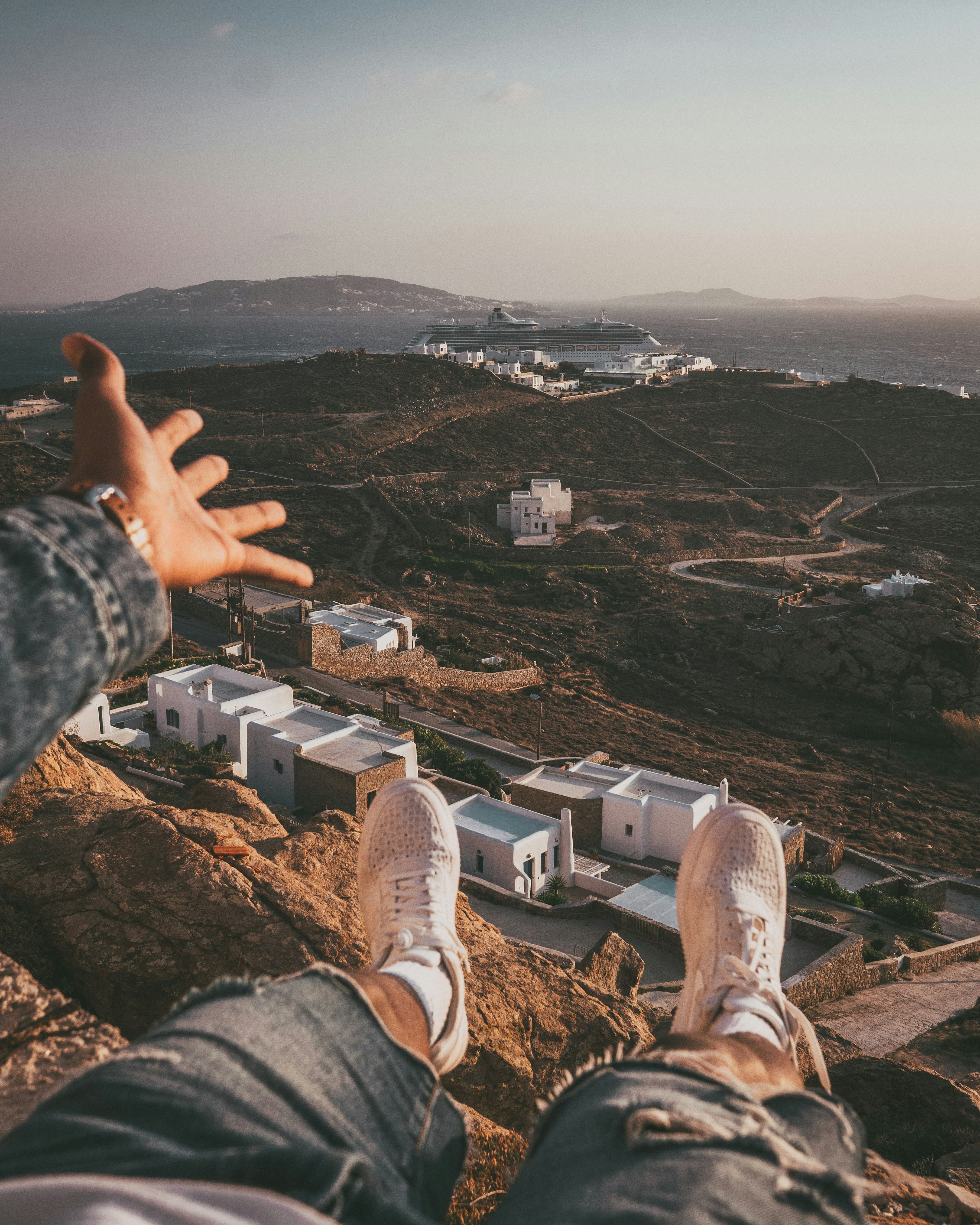 person on cliff taking photo of houses